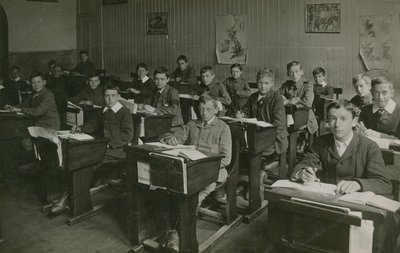 Mannelijke leerlingen zitten achter hun bureaus tijdens een les op school door English Photographer